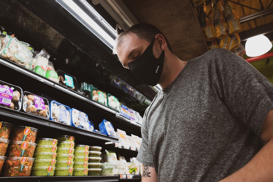 man in gray crew neck t-shirt standing near shelf