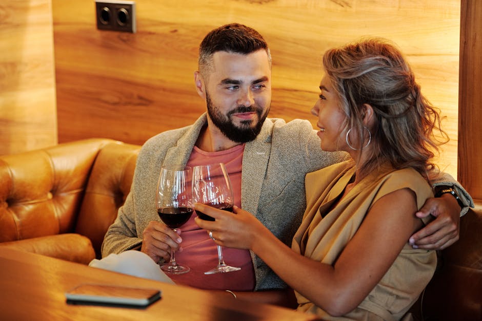 A couple enjoys a romantic evening with wine in a stylish indoor restaurant setting.