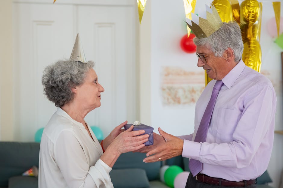 Happy senior couple exchanging gifts during a birthday celebration at home.