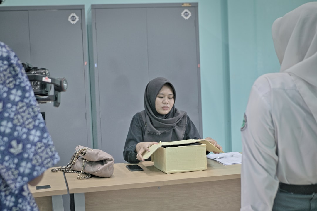 Woman in hijab at desk with papers